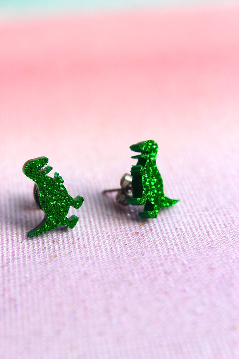 Glimmer dino ørestikker i plexiglas