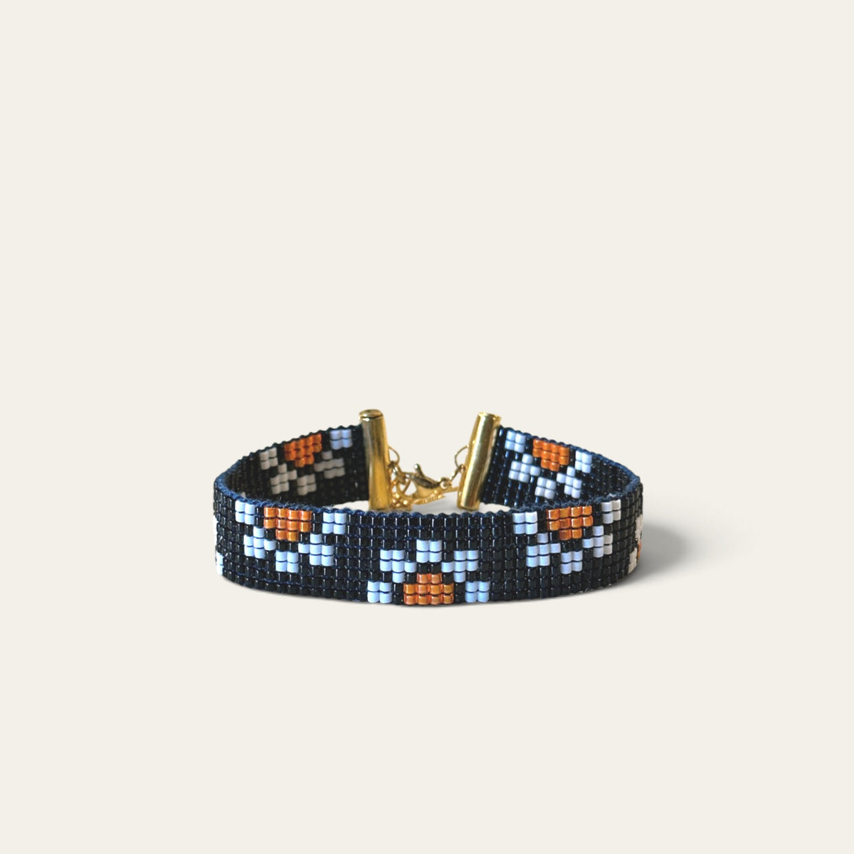 Armbånd i miyukiperler – sort med hvide blomster og orange | Sara Engel