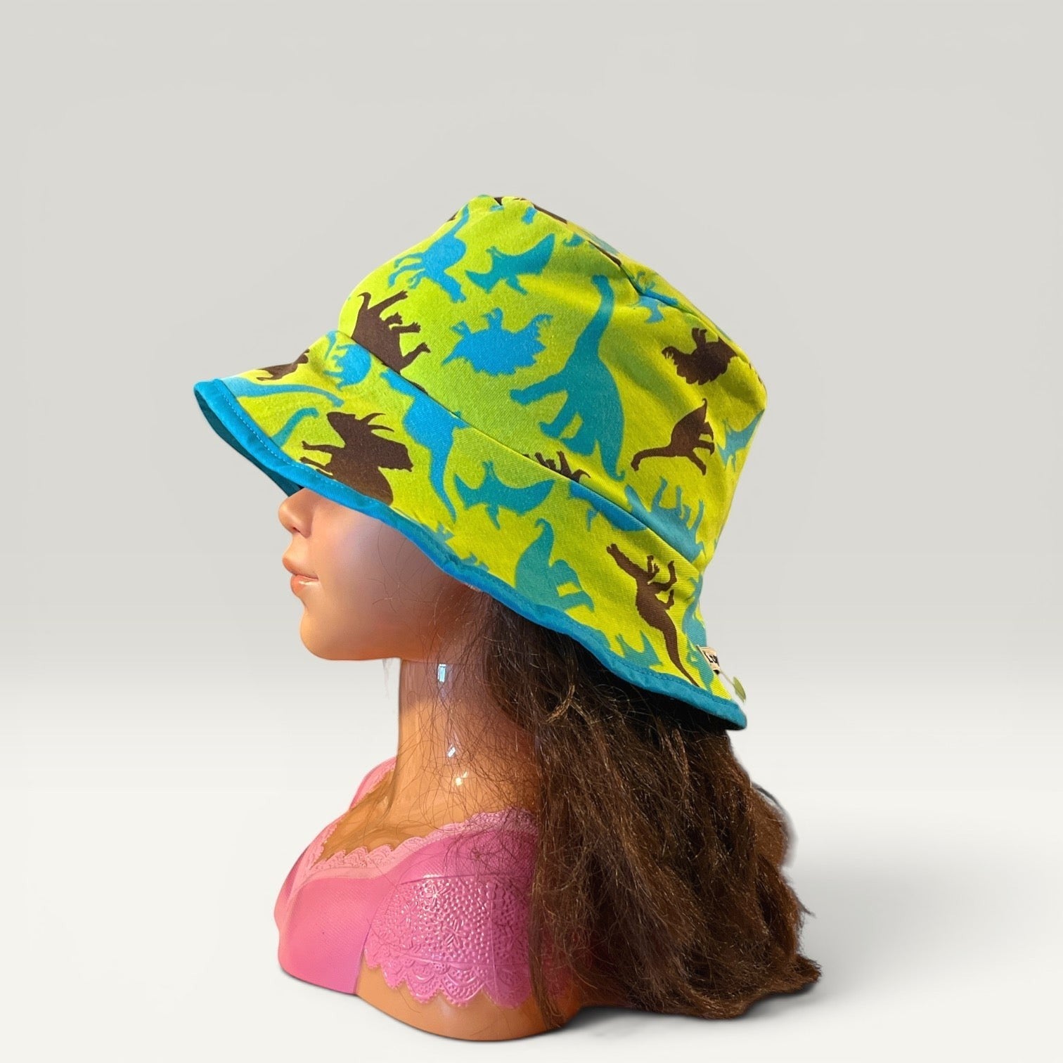 Håndlavet af reversible bucket hat for kids, lime green with dinosaur print and blue trim. Size 50 (6-12 months).