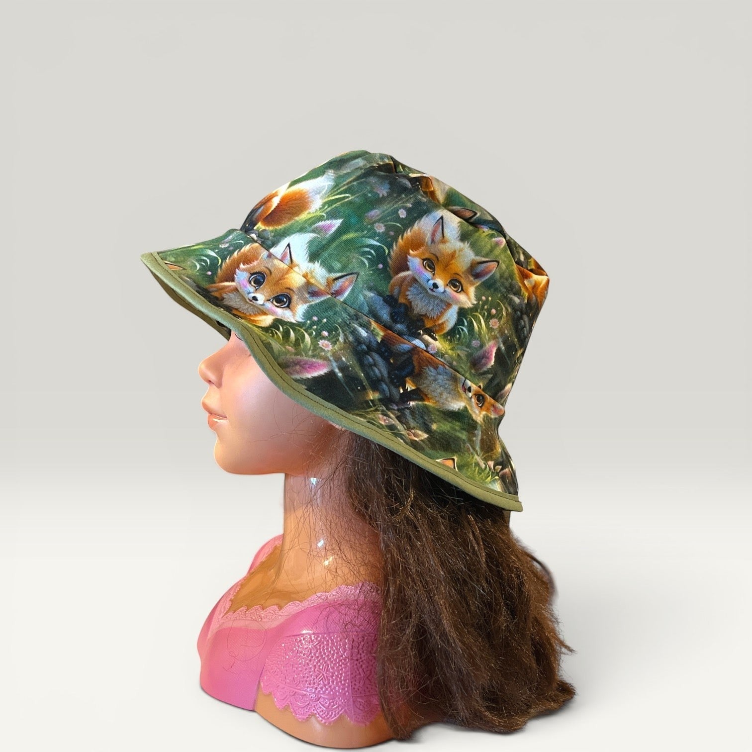 Håndlavet af reversible bucket hat for kids, size 50, with a cute fox print on green background. Jersey material.