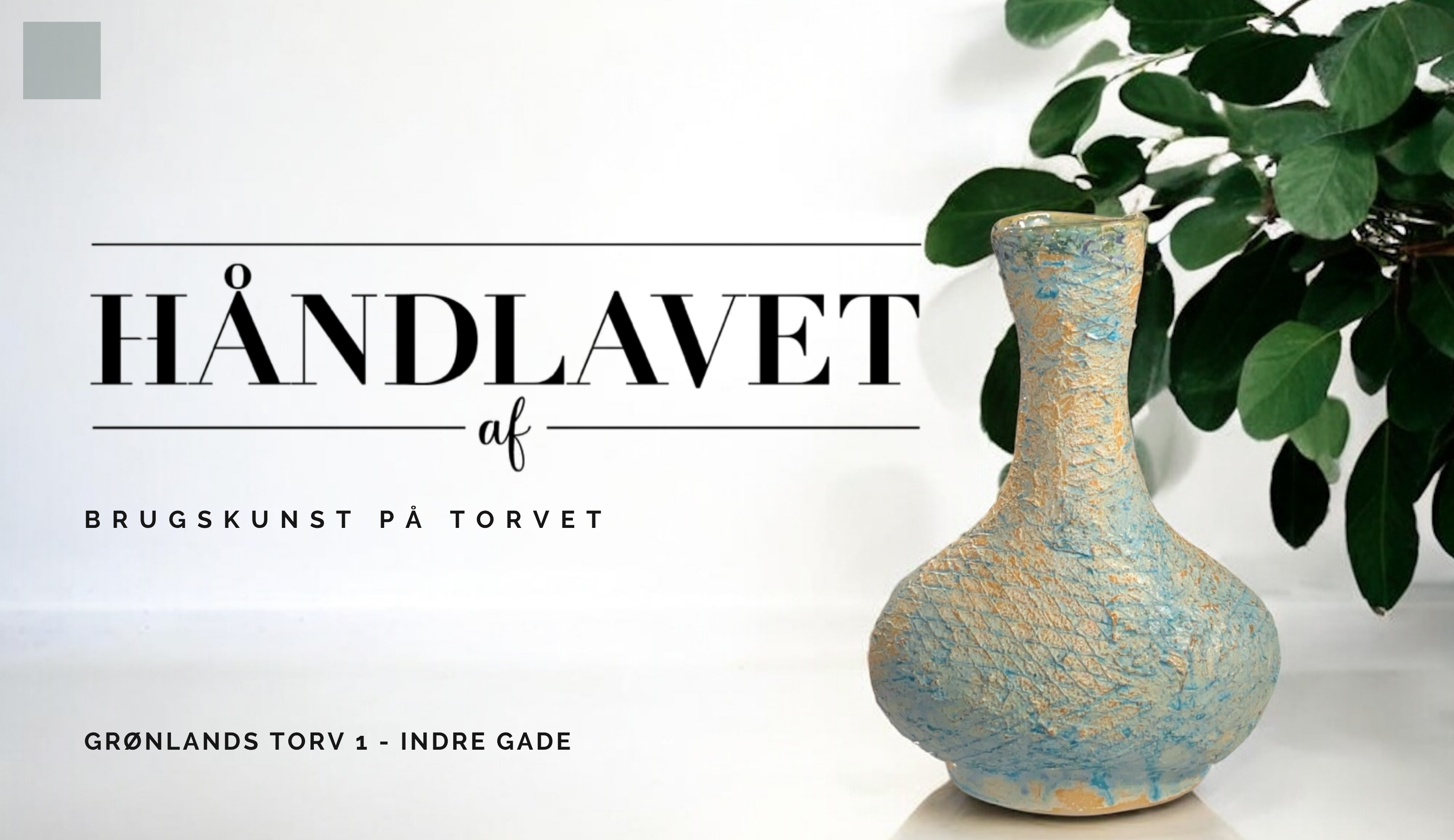 billedet viser en vase i sand og lys blå der står på en lys flade. Teksten på billedet er "Håndlavet af - brugskunst på torvet, grønlands torv 1 - indre gade".